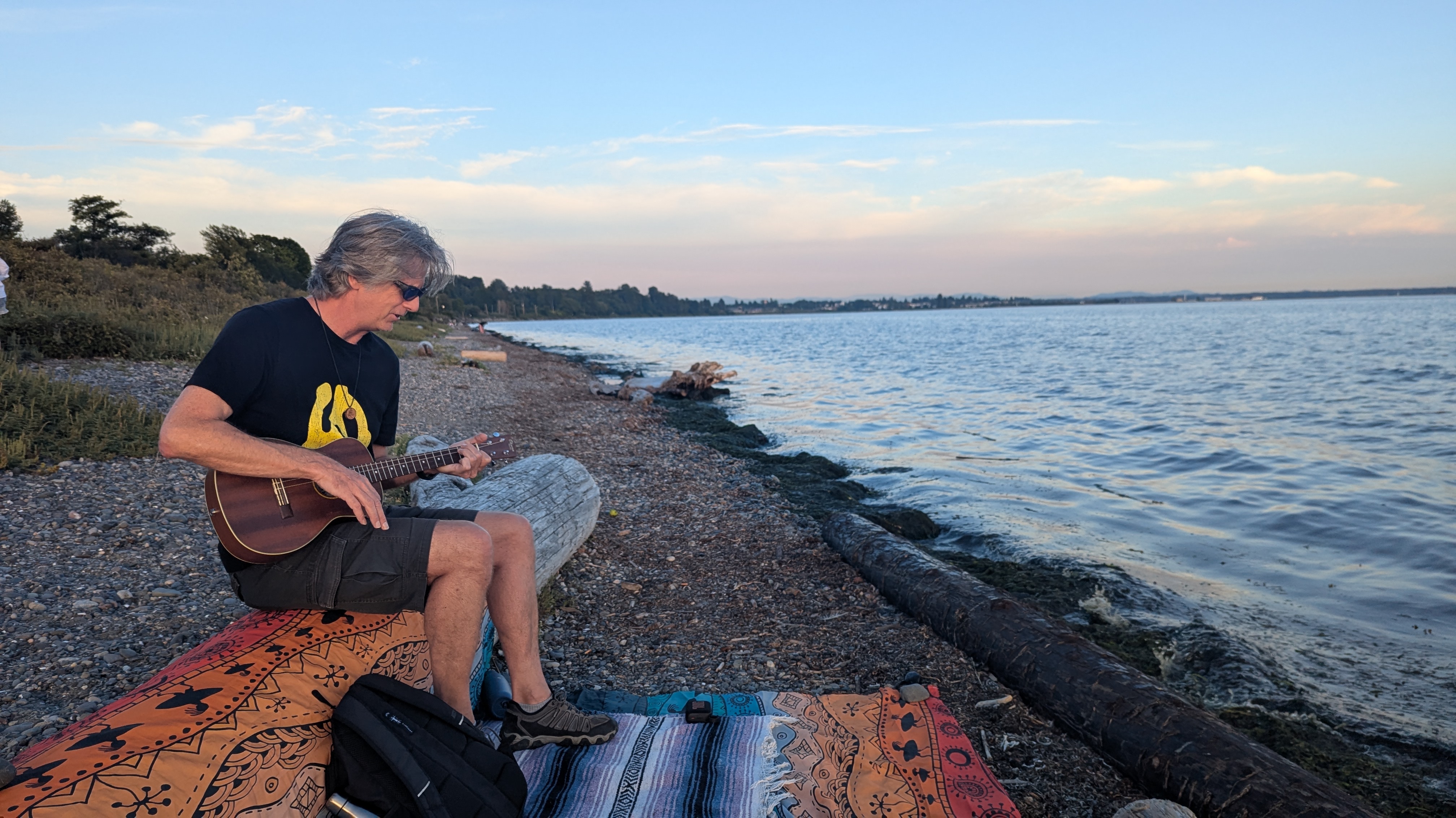 Iggy Pot playing baritone ukulele on the beach